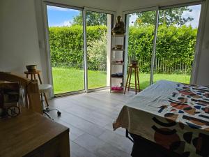 a bedroom with a bed and sliding glass doors at Chambre privée proche GR & Véloroute in Plougonvelin