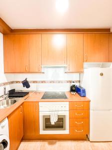 a kitchen with a stove and a white refrigerator at Apartamento MN Estorde by ALÔGA in Vilar