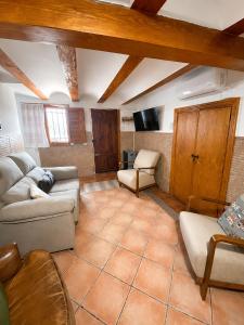a living room with two couches and a tv at La Casonita in Alpuente