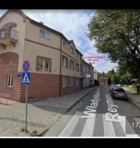 a street with a building and a car parked on the road at Zacisze 4 in Przemyśl