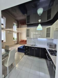 a kitchen with a sink and a couch in a room at Nest & Rest StuDio in Stavcheny