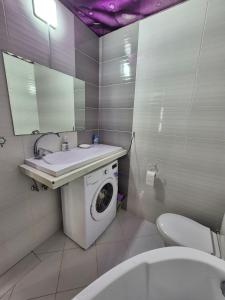 a bathroom with a washing machine and a sink at Nest & Rest StuDio in Stavcheny