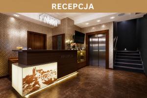 a lobby with a reception desk and a staircase at Hotel Miodowy Młyn in Opatów