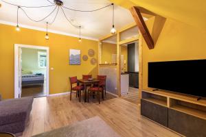 a living room with a tv and a table with chairs at Altstadt Quartier in Bad Freienwalde