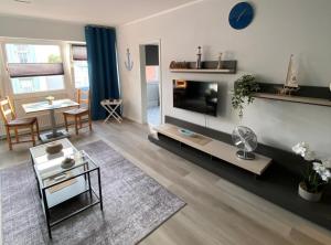 a living room with a television and a table at Gemütliche Ferienwohnung im Lotsenviertel in Cuxhaven