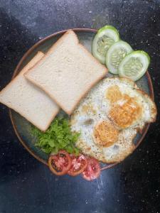 a plate of food with eggs and bread and vegetables at Tam Cốc mountain view Villa in Ninh Binh