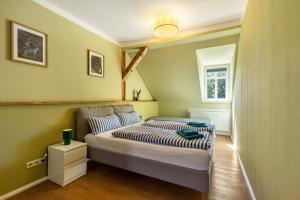 a small bedroom with a bed with striped sheets at Altstadt Quartier in Bad Freienwalde