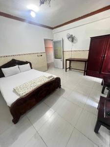 a bedroom with a bed and a desk and a fan at Khách Sạn Vũ Nam Hưng in Ấp Hưng Lộc +19 photos