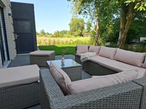 a patio with two wicker couches and a table at Das Strandhaus am Dümmer See in Lembruch