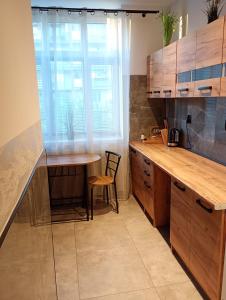 a kitchen with wooden cabinets and a table and a window at Zacisze 4 in Przemyśl
