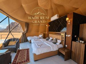 a bedroom with two beds and a couch in a tent at WADI RuM GRAND in Wadi Rum