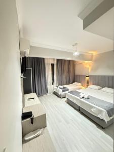 a hotel room with two beds and a mirror at Side Ertaş Otel in Side