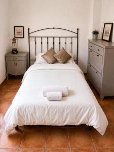 a bedroom with a large white bed with two night stands at La Casonita in Alpuente