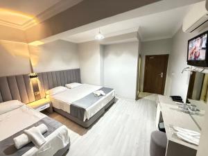 a hotel room with two beds and a flat screen tv at Side Ertaş Otel in Side +9 photos