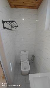 a white bathroom with a toilet and a sink at Forest Hotel in Miarinarivo