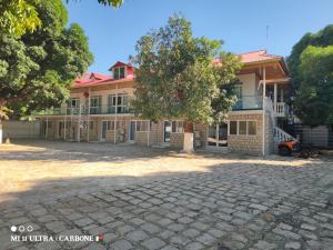 a building with a tree in front of it at Forest Hotel in Miarinarivo