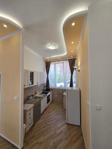 a kitchen with white cabinets and a white refrigerator at Villa Iper Krystallos in Budva