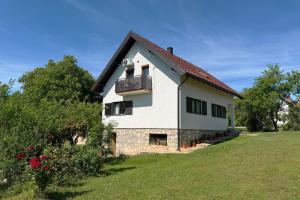 a white house on a hill with a yard at Cherry Hill Loft in Plitvička Jezera