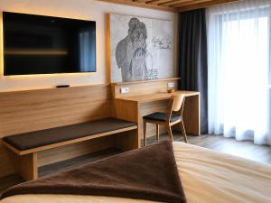 a hotel room with a desk and a television at Landhotel Kaserer in Bramberg am Wildkogel