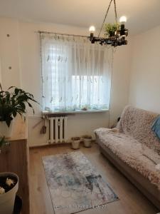 a living room with a couch and a window at Sleep & Chill in Leszno