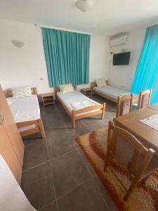 a living room with two beds and a table at Apartmani Blu Notte in Ulcinj