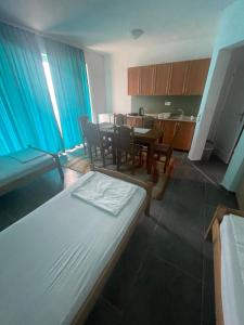 a room with a bed and a table and a kitchen at Apartmani Blu Notte in Ulcinj