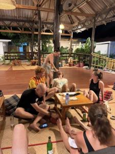 a group of people sitting around a table at Lazy Garden Hostel in Phra Ae beach
