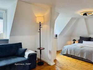 a bedroom with a bed and a couch and a lamp at URBAN STAY Hamburg - Apartments "BACKBORD" & "STEUERBORD mit Sauna" in Hamburg