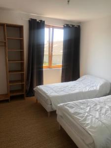 two beds in a room with a window at Idéalement placée in Santec