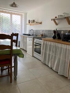 a kitchen with a table and a stove top oven at Idéalement placée in Santec