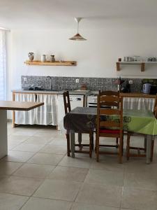 a kitchen with a table and two chairs and a table and a table at Idéalement placée in Santec +12 photos