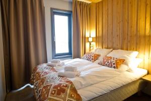 a bedroom with a large bed with towels on it at Skistar Lodge Trysil in Trysil +24 photos