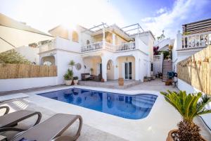 a villa with a swimming pool in front of a house at Rd02 La Casa Hermosa in Torrox
