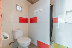a bathroom with a toilet and red stripes on the wall at Oaxaca Venado in Agaete +18 photos