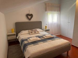 a bedroom with a bed with two towels on it at Lake House Gerês in Admeus +16 photos
