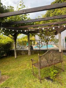 a park bench under a pergola with a swimming pool at Lake House Gerês in Admeus