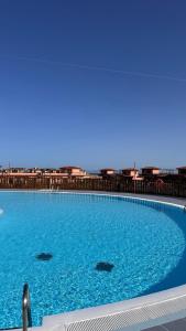 a large pool of blue water with buildings in the background at Fuerte Wave House in Lajares
