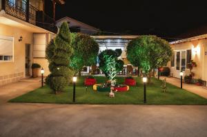 a garden with trees and lights in a courtyard at Kalinovi Apartments in Gevgelija +16 photos