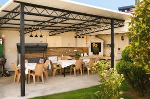 a patio with tables and chairs and a grill at Kalinovi Apartments in Gevgelija