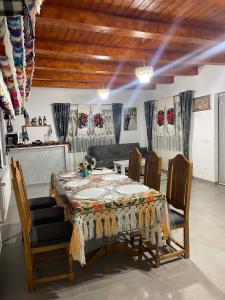 a living room with a table with chairs and a couch at Casa Moroseneasca Breb in Breb