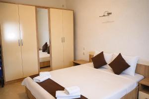 a bedroom with a large white bed with a mirror at Kalinovi Apartments in Gevgelija