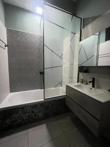 a bathroom with a glass shower and a sink at Le felix in Antananarivo