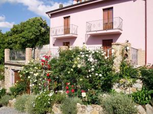 ein weißes Haus mit Blumen davor in der Unterkunft Residenza Locci - Rooms & Apartments in Teulada