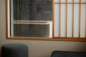 a window with blinds in a room with a chair at soyo-ka kyoto sanjo in Kyoto