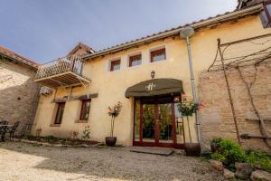 a stone building with a door and a balcony at Divas Upes SPA hotel Koknese in Koknese