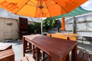a wooden table with an umbrella on a patio at Ahaura Hotel in Greymouth