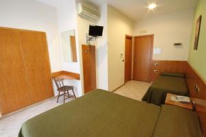 - une chambre avec un lit vert et un bureau dans l'établissement Hotel Zara Napoli, à Naples