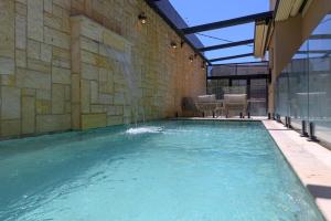 a swimming pool in a building with a water fountain at Villa Lausanne - View in Dāliyat el Karmil