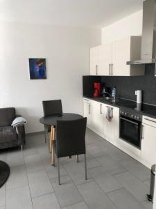 a kitchen with white cabinets and a table and chairs at Ferienwohnung Mosel in Piesport