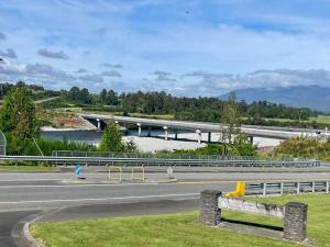 a highway with a bridge in the background and a river at Ahaura Hotel in Greymouth